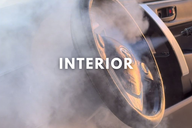 Interior deep cleaning with steam applied to a car’s steering wheel for thorough sanitization.