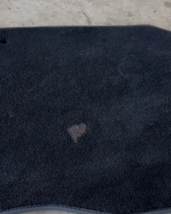 Stain on car carpet in Truganina before professional steam cleaning, a service offered near Werribee.